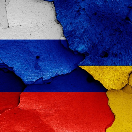 Symbolbild: Zerbröckelnder Putz in den Nationalfarben Russlands und der Urkaine