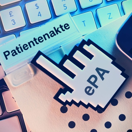 Computercursor zeigt auf Patientenakte auf einer Computertastatur