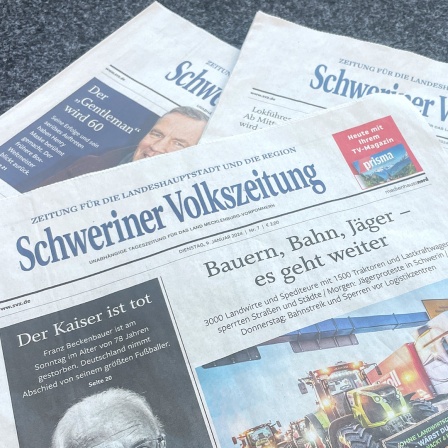 Mehrere Ausgaben der Schweriner Volkszeitung liegen aufeinander. Zuoberst liegt die die Ausgabe vom 9. Januar 2024 mit den Schlagzeilen "Der Kaiser ist tot" und "Bauern, Bahn, Jäger - es geht weiter".