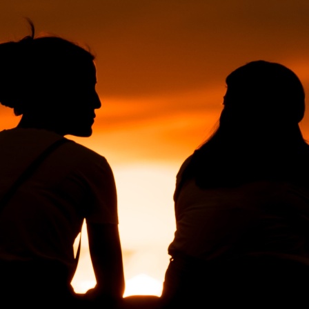 Silhouette zweier Frauen vor Sonnenuntergang