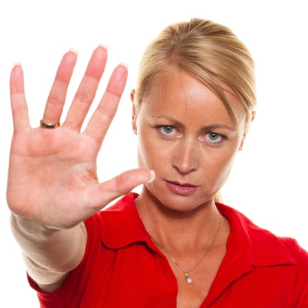 Frau signalisiert &#034;Stop&#034; mit der ausgestreckten Hand: Wer meldet sich im Internet gegen Hassrede zu Wort? Wer mischt sich ein, wenn jemand im Bus bedroht oder am Arbeitsplatz diskriminiert wird? Menschen, die couragiert dagegenhalten, widerstehen dem Druck, sich einer Mehrheit anzupassen. Sie zeigen sozialen Mut und Handlungskompetenz.