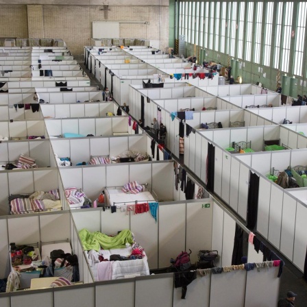 Provisorische Zimmer mit Betten sind in einer Notunterkuenft fuer Fluechtlinge im ehemaligen Hangar des Flughafen Tempelhof aufgebaut. 