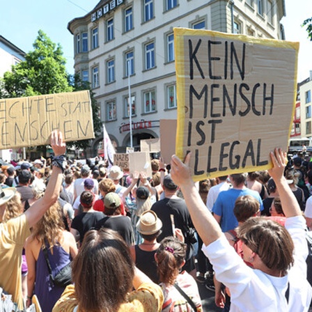 Demo mit Schildern "Menschenrechte statt rechte Menschen" und "Kein Mensch ist illegal"