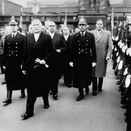 Bundeskanzler Konrad Adenauer (2.v.l.) schreitet am 1. Januar 1957 die Polizeihundertschaft ab, hinter ihm der Ministerpräsident der Saarregierung, Hubert Ney