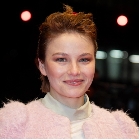 Ein Porträt der Schauspielerin Devrim Lingnau vor dunklem Hintergrund auf der Berlinale 2025