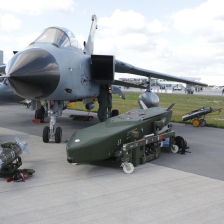 Ein Tornado-Kampfjet steht auf dem Rollfeld eines Flughafens, davor liegt ein Luft-Boden-Marschflugkörper vom Typ Taurus.