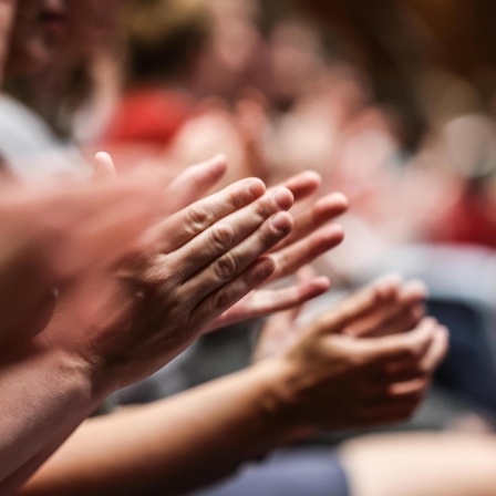 Nahaufnahme applaudierender Hände.