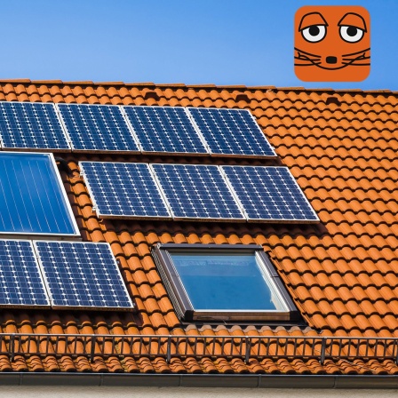 Dunkle Solarpaneele auf einem orangenen Dach schimmern in der Sonne
