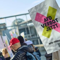 Mann hält Plakat auf dem steht: "AfD Verbot Jetzt".