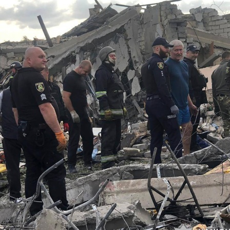 Rettungskräfte suchen nach Opfern eines russischen Raketenangriffs, bei dem mindestens 49 Menschen in dem Dorf Hroza in der Nähe von Charkiw getötet wurden.