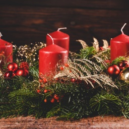 Roter Adventskranz mit vier roten Kerzen. Symbol für Weihnachten und Advent