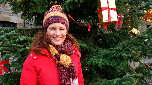 Moderatorin Anne Willmes steht auf dem Weihnachtsmarkt in Engelskirchen vor einem geschmückten Tannenbaum