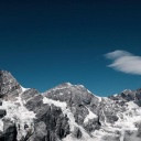 Ein Panorama aus schneebedeckten Berggipfeln vor stahlend blauem Himmel.