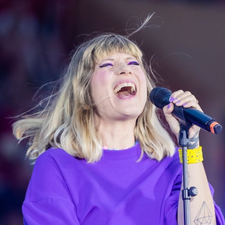 Mieze Katz singt während eines Konzerts in ein Mikrofon.
