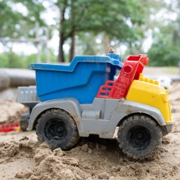 Sandspielzeug in einem Sandkasten auf einem Spielplatz.