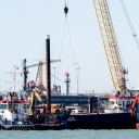 Mehrere Pontons und Schwimmkräne liegen an der Baustelle für das geplante LNG-Terminal in der Nordsee vor Wilhelmshaven.