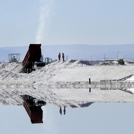 Menschen und Fahrzeuge spiegeln isch in Salzbecken des Lithiums-Abbaus in Atacama, nahe Calama city, in Chile.