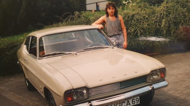 ein altes Foto eines alten Autos mit seinem Besitzer