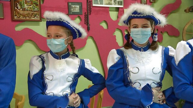 Zwei junge Mädchen in blauem Karnevalkostüm und Mund-Nasen-Schutz.