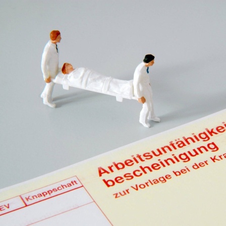 Figuren von Sanitätern mit einer Trage neben einer Arbeitsunfähigkeitsbescheinigung