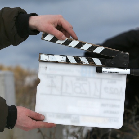 Ein Film-Team-Mitarbeiter hält eine Filmklappe.