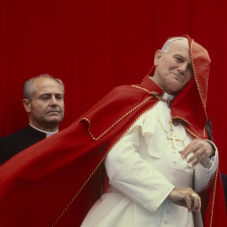 Johannes Paul II. mit wehendem roten Umhang im päpstlichen Ornat.
