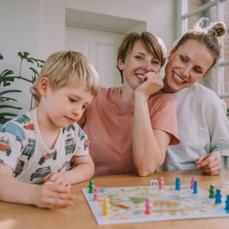 Zwei Frauen und ein Junge bei einbem Brettspiel