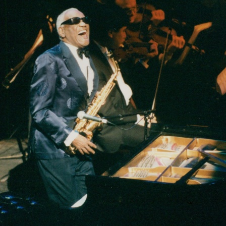 Ray Charles singt mit Saxophon und  Klavier auf der Bühne 1995.
