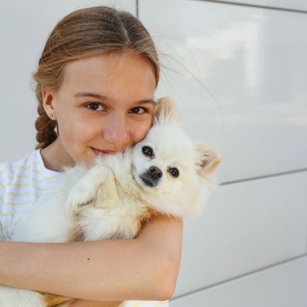 Mädchen mit Hund auf dem Arm