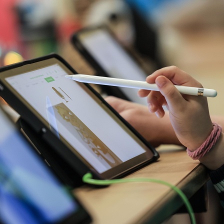 Schüler lernen in einer Klasse in der Grundschule Sandstraße am iPad. An nordrhein-westfälischen Schulen fehlen Lehrerinnen und Lehrer. Mehr als 8000 Stellen sind unbesetzt. Die Landesregierung versucht mit einem Maßnahmenpaket gegenzusteuern.