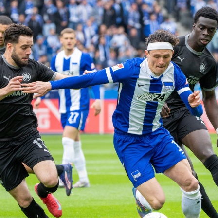 Fabian Reese (M) setzt sich gegen Fürths Niko Gießelmann (l) und Joshua Quarshie (r) durch