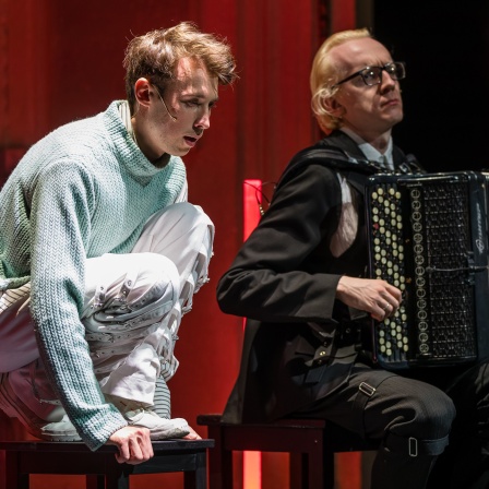 Der Schauspieler Torben Appel (Alan) und Live-Musiker Aliaksandr Yasinski sitzen auf der Bühne des Staatstheaters Cottbus bei einer Fotoprobe für den Thriller "Equus" von Peter Shaffer