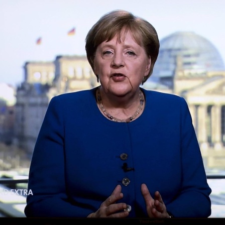 Angela Merkel ist im Fernsehen zu sehen. Zum ersten Mal in ihrer 15-jährigen Amtszeit wendet sie sich außerhalb der jährlichen Neujahrsansprache direkt an die Bevölkerung