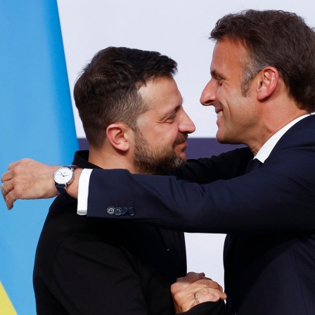 Der ukrainische Präsident Wolodymyr Selenskyj (l) und der französische Präsidenten Emmanuel Macron umarmen sich