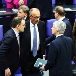Friedrich Merz (CDU) steht zwischen Jens Spahn und weiteren Kollegen und reagiert auf die gescheiterte Wahl zum Kanzler