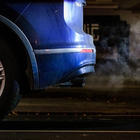Abgase kommen aus dem Auspuff eines Volkswagen Tiguan auf nasser Straße.