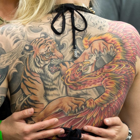 Ein Tiger und ein Drache sind am 21.03.2015 auf der "International Tattoo-Convention" in Frankfurt am Main (Hessen) auf dem Rücken einer Frau zu sehen.