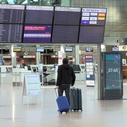 Ein Reisender steht im Terminal 1 am Flughafen Hamburg vor einer Anzeigetafel, auf der nur wenige Flüge für den Tag zu sehen sind. 