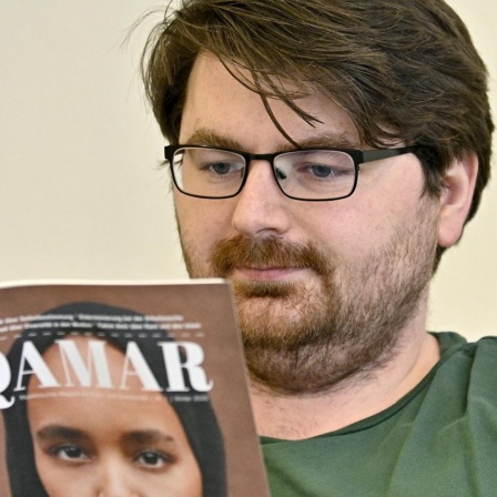 Muhamed Beganovic, Gründer des muslimischen Magazins "Qamar" blättert durch eine Ausgabe seines Magazins.