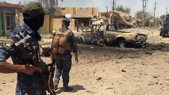 Zwei Irakische Soldaten patrouillieren auf einer Straße.