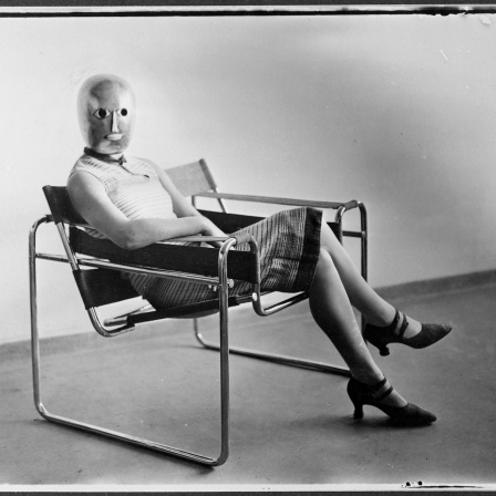 Sitzende mit Bühnenmaske von Oskar Schlemmer im Stahlrohrsessel von Marcel Breuer, um 1926