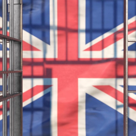 Eine offene Gefängnistür vor der Flagge Großbritanniens.