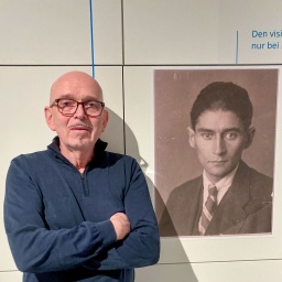 Hans-Gerd Koch steht neben einem Kafka Porträt in der Ausstellung "Das Fotoalbum der Familie Kafka" im Kulturwerk der Staatsbibliothek Unter den Linden  © Anne-Dore Krohn