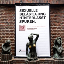 Ein Plakat mit der Aufschrift „Sexuelle Belästigung hinterlässt Spuren“ hängt hinter der Bronzeskulptur „Jugend“ des Künstlers Bernhard Hoetger.
