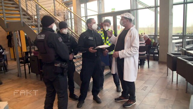 Polizisten kontrollieren einen Restaurantbetrieb.
