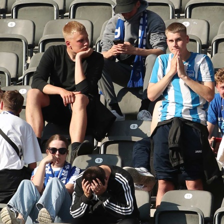 Herthafans sitzen enttäuscht nach dem Abstieg auf der Tribüne.