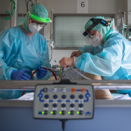 Intensiv-Pflegekräfte versorgen einen schwer an Corona erkrankten Patienten auf einer Intensivstation.