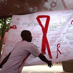 Ein Mann hängt ein Banner am &#034;Wits Reproductive Health and HIV Institute&#034; anlässlich des Welt-Aids-Tages mit dem Kampagnenmotto "Getting to Zero" in Johannesburg, Südafrika auf. (Archivfoto)