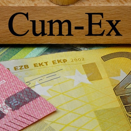 Auf Geldscheinen steht ein Stempel mit dem Schriftzug Cum-Ex.