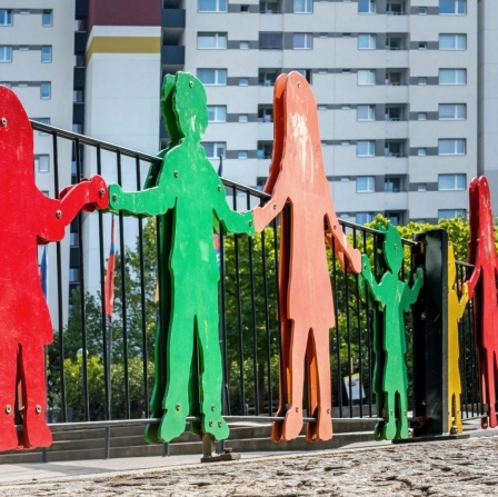 Bunte Silhouetten von Kinderfiguren an einem Kinderspielplatz. 
